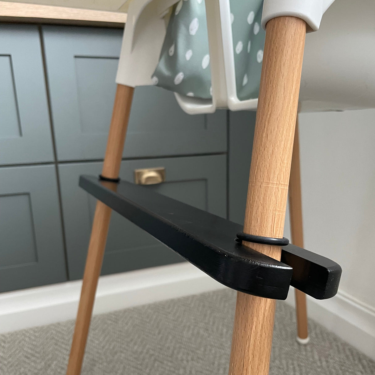 side view of black footrest on IKEA highchair leg
