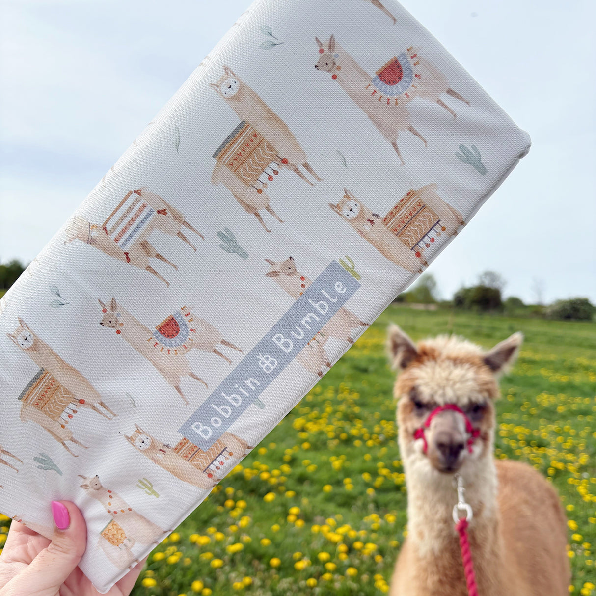 Alpaca design folded changing mat with an alpaca in a field in the background