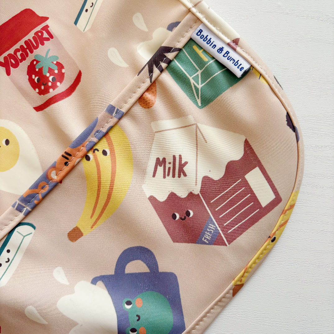 Baby bib with food-themed design on a light background. Bobbin and Bumble label
