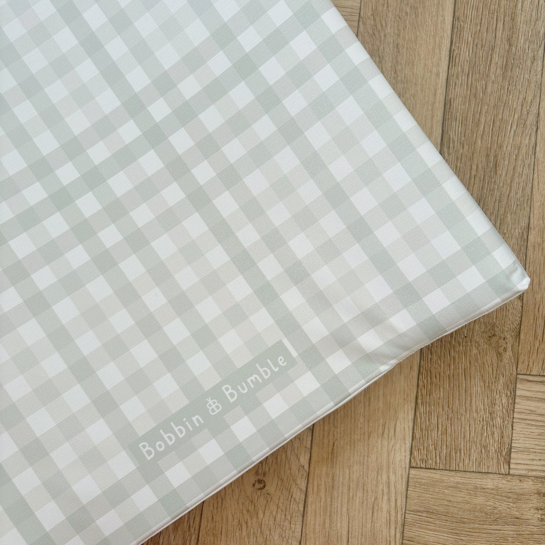 Checkered wedge changing mat with 'Bobbin & Bumble' branding on a wooden surface