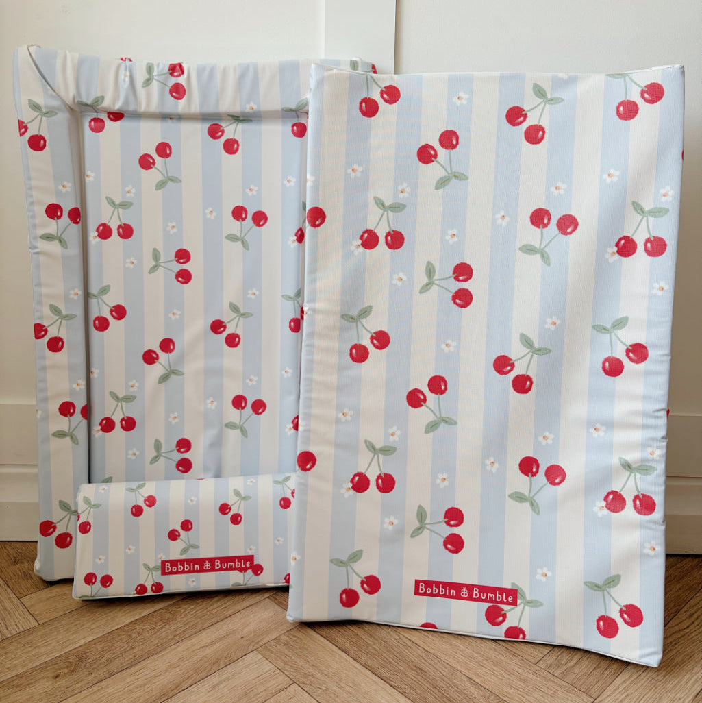three Changing mats with cherry pattern on a wooden floor