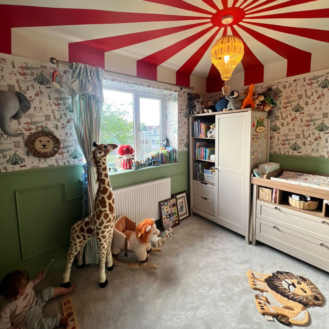 Children's room with a red and white striped ceiling, toys, and bookshelves.