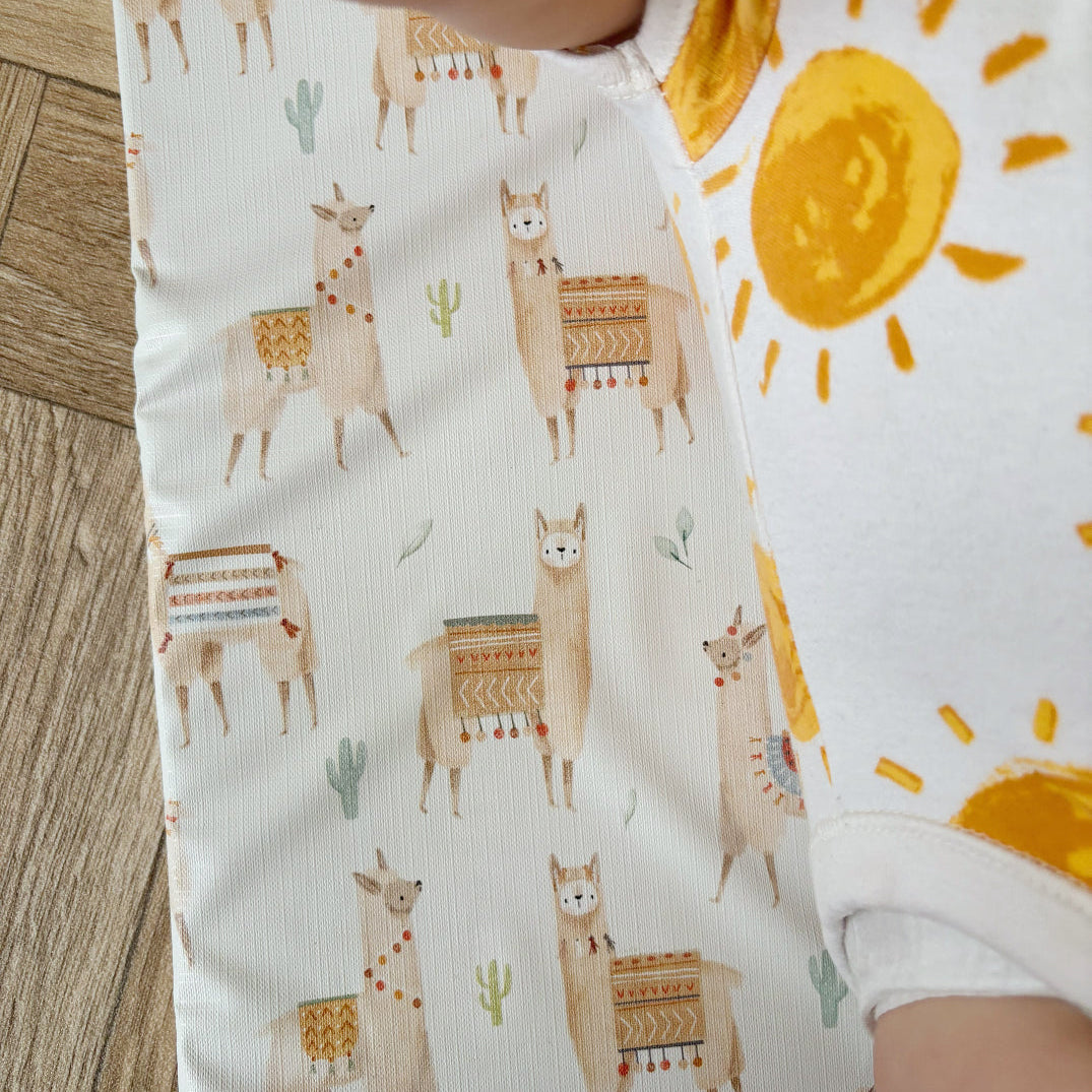 Fabric with llama and sun pattern on a wooden surface