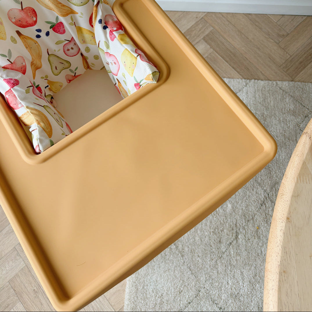 Yellow high chair with a floral cushion on a wooden floor.
