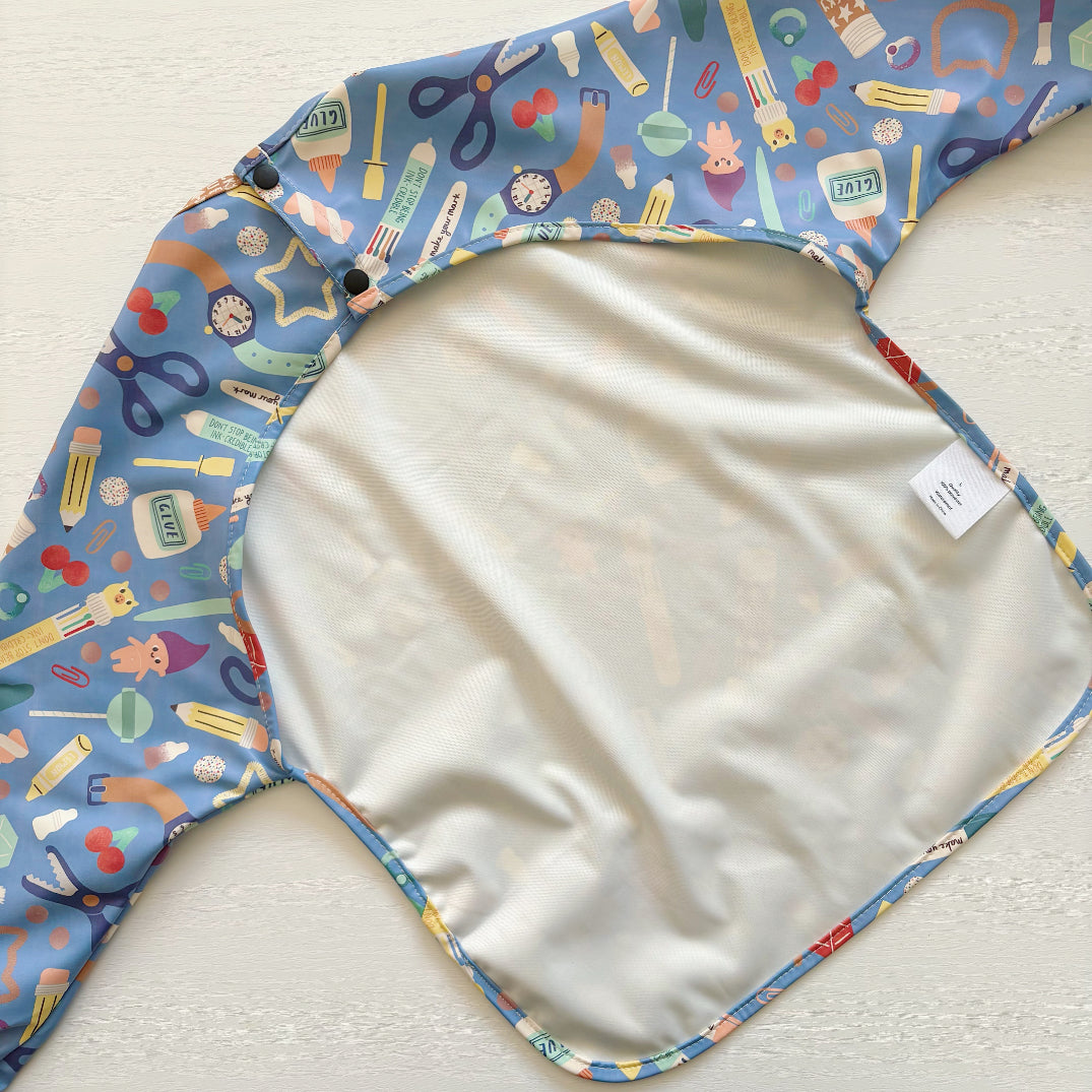 Back of a baby bib with colourful stationary pattern on a light background