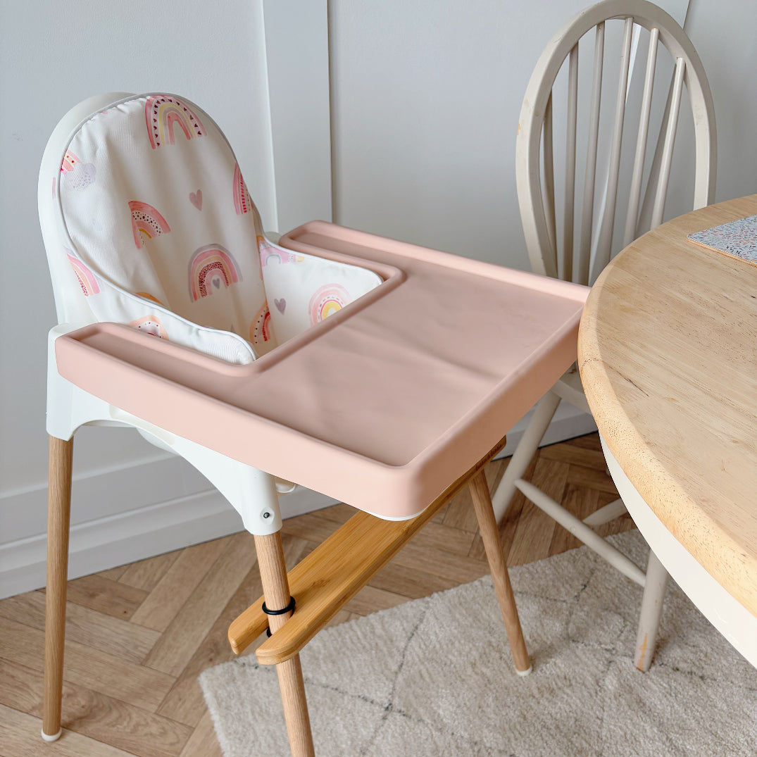 IKEA highchair with rainbow cushion cover and light pink silicone tray mat