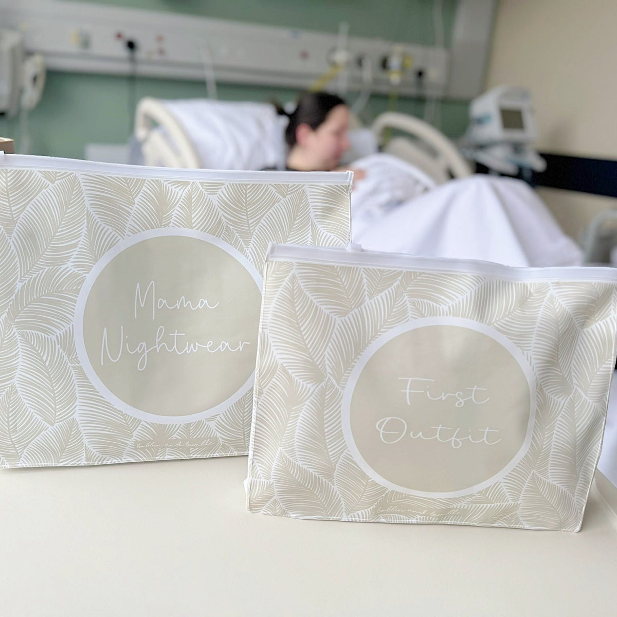 mum and baby hospital organiser bags with text on that says mama nightwear and first outfit. Background is mum and baby in hospital room