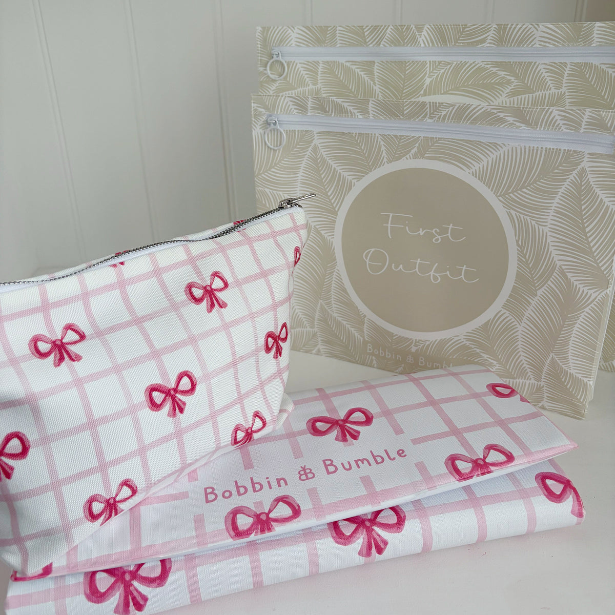 Pink and white bag with red bows and a clear pouch with text on a light background