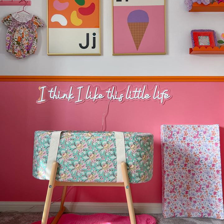 Colourful pink nursery with LED light that says I think I like this little life.