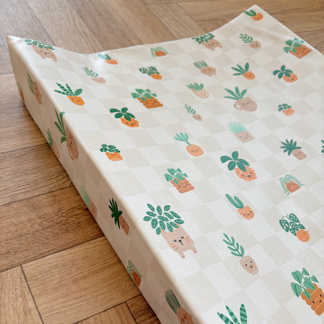 Wedge baby changing mat with pot plant pattern on a wooden floor