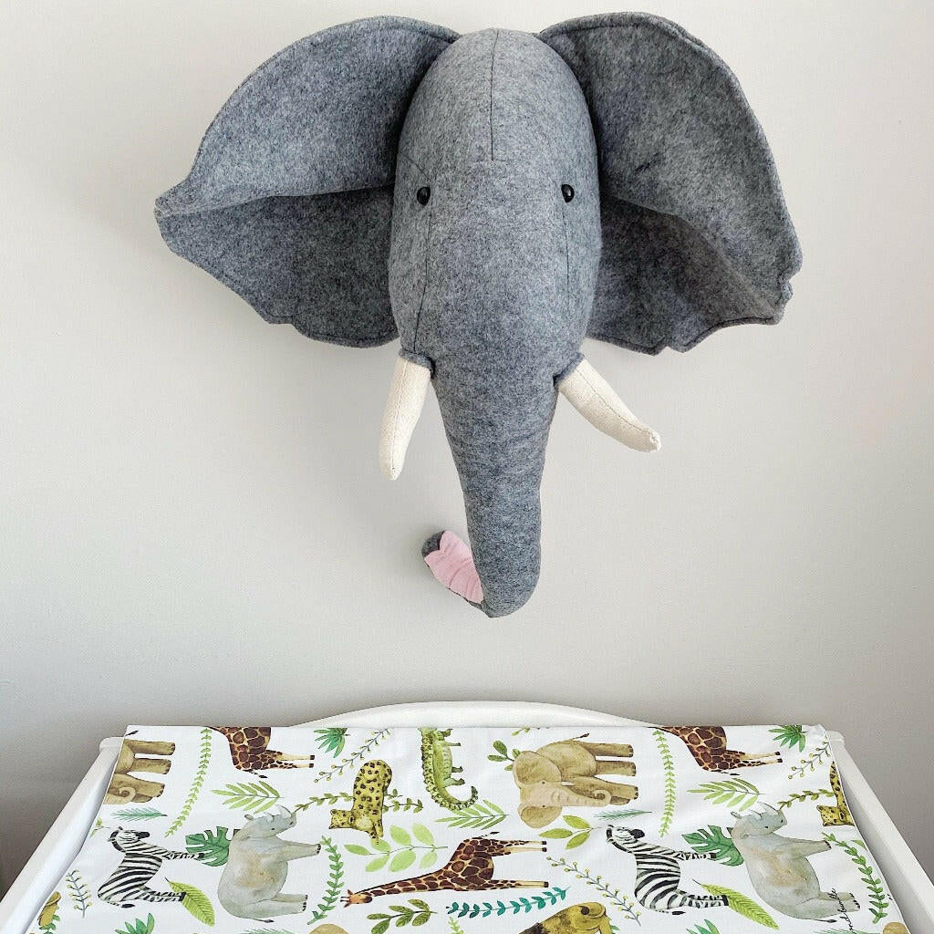Anti-Roll Wedge Changing Mat - Safari Animals Print with a toy elephant head above on a grey background