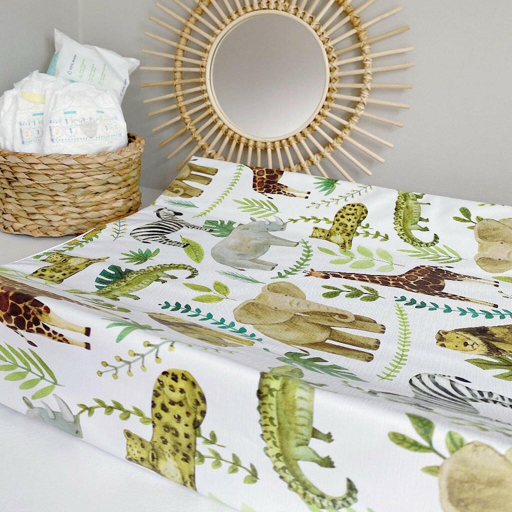 Anti-Roll Wedge Changing Mat - Safari Animals Print with rattan sunburst mirror against grey background