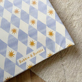 wedge baby changing mat with blue and white checkered pattern and yellow stars on a textured surface