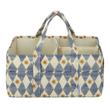 A fabric storage organizer bag with a blue and cream harlequin diamond pattern and small orange starburst accents, featuring two top handles and an open top design.