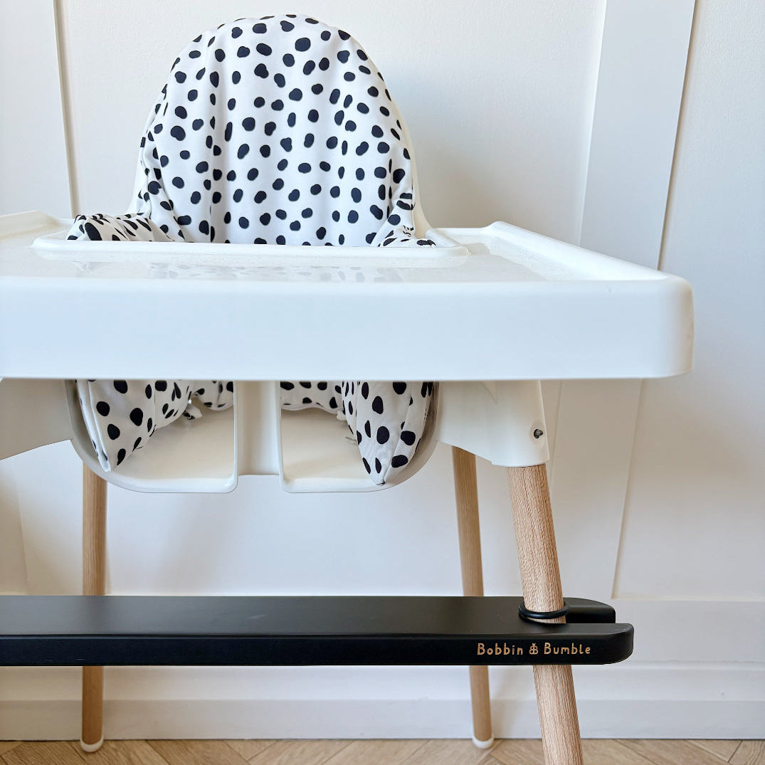 IKEA highchair with black spotty cover and black bobbin and bumble branded footrest