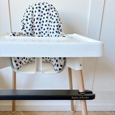 IKEA highchair with black spotty cover and black bobbin and bumble branded footrest