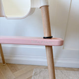 IKEA highchair with Pink footrest 'Bobbin and Bumble branding on a wooden floor.