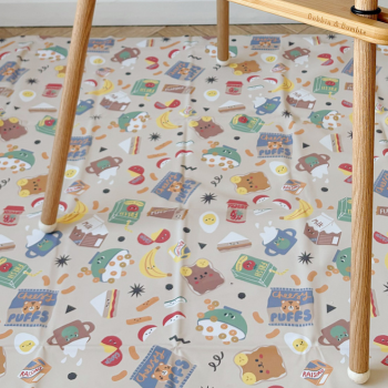 Patterned play mat on a wooden floor with a chair