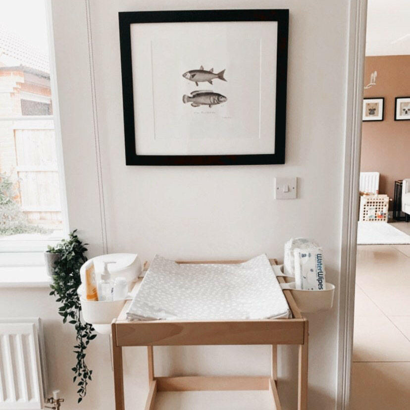 Changing table set up with a large picture above. 