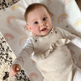 baby on a rainbow wedge changing mat. Cream and black rug below it